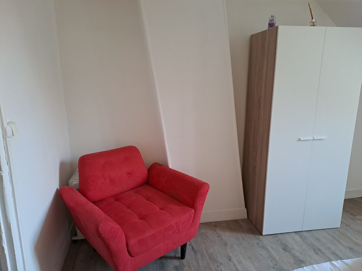 Chambre Gordini, fauteuil rouge vintage et armoire blanche sous combles — KM99 Pont-sur-Yonne