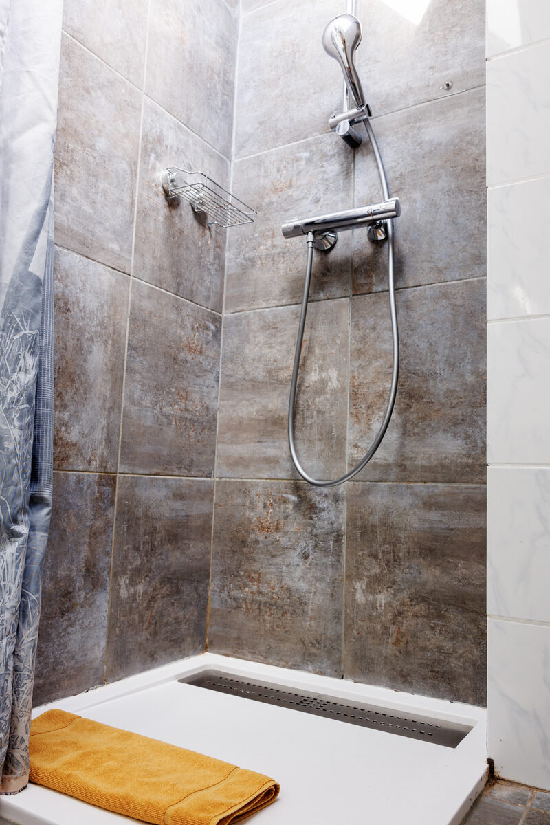 Salle de bain L'Indus, douche à l'italienne carrelage pierre, receveur blanc — La Graineterie